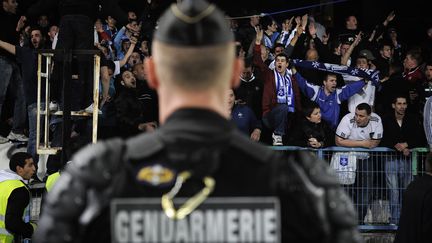 Un gendarme mobile fait face aux supporters auxerrois qui protestent contre la direction du club, le 20 mai 2012, au stade de l'Abb&eacute;-Deschamps, &agrave; Auxerre.&nbsp; (JEFF PACHOUD / AFP)