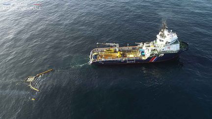 Un navire de la Marine nationale installe une bouée pour contenir le pétrole du "Grande America", le 22 mars 2019. (HANDOUT / MARINE NATIONALE / AFP)