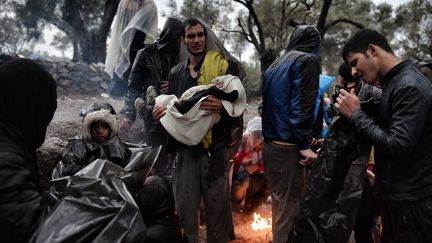 Migrants sous la pluie à Lesbos en 2015
 (Aris MESSINIS / AFP)