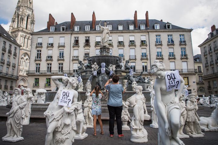 Les statues de l'œuvre "Reconstituer", de l'artiste contemporain Stéphane Vigny, recouvertes d'affiches "où est Steve ?" sur la place Royale de Nantes, le 12 juillet 2019. (LOIC VENANCE / AFP)