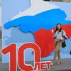 Une femme pose pour une photo devant une installation célébrant les 10 ans de l'annexion de la Crimée par la Russie, le 13 mars 2024, à Simferopol. (AFP)