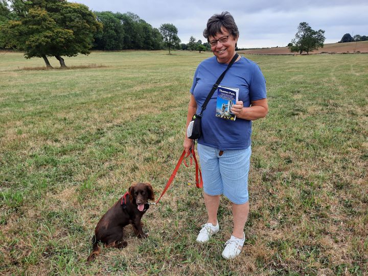 La randonneuse Nicole, avec son chien Molly, guide des bords de la Tamise à la main. (AGATHE MAHUET / RADIO FRANCE)