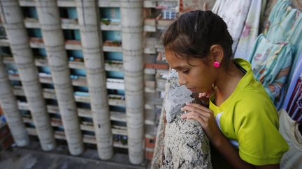 Genesis (9 ans) sur le balcon de l’appartement où elle vit avec ses parents et ses quatre frères et sœurs.
 (Jorge Silva / Reuters)