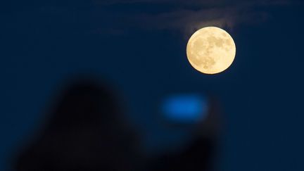 Une personne tente de photographier la "super Lune" à Broughty Ferry, en Ecosse, le 1er janvier 2018. (WP#ECAF/WENN.COM/SIPA / SIPA USA / AFP)