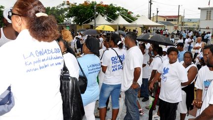 Des Guadeloup&eacute;ens manifestent le 30 juin 2013 &agrave; Petit-Bourg (Guadeloupe), apr&egrave;s la mort de six personnes d'une m&ecirc;me famille. (EDDY NEDELKOVSKI / AFP)