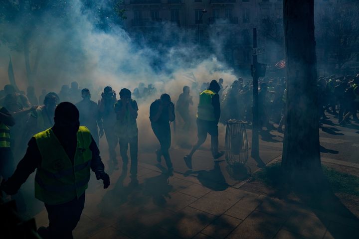 Des "gilets jaunes" manifestent sous les gaz lacrymogènes, le 20 avril 2019, à Paris. (LIONEL BONAVENTURE / AFP)