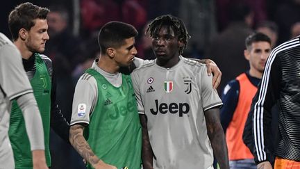 Le défenseur Portugais Joao Cancelo réconforte Moise Kean, alors que des supporters de Cagliari ont jeté des projectiles et proféré des cris de singe après son but. (MARCO BERTORELLO / AFP)