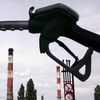 Un pistolet de pompe de station-service avec derrière une raffinerie à Grandpuits (Seine-et-Marne). (JOEL SAGET / AFP)