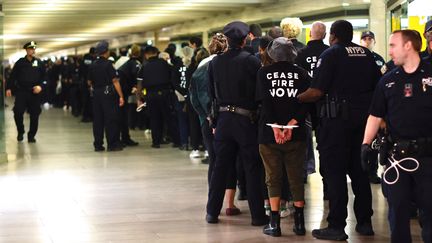 Des militants protestant contre l'offensive israélienne à Gaza sont arrêtés après une manifestation dans la gare de Grand Central, à New York (Etats-Unis), le 27 octobre 2023. (KENA BETANCUR / AFP)