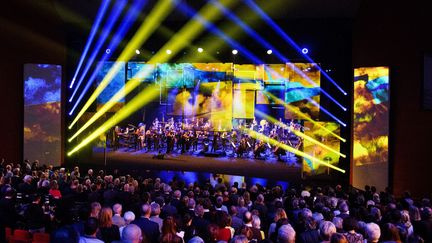 Victoires de la musique classique, le 9 mars 2022 : sous la direction de la cheffe d'orchestre Ariane Matiakh,&nbsp;l'Orchestre philharmonique de Nice a joué l'hymne ukrainien devant un public debout, tandis que les couleurs du drapeau -jaune et bleu- ont été projetées sur des panneaux vidéo mobiles au-dessus de la scène. (CLEMENT MAHOUDEAU / AFP)