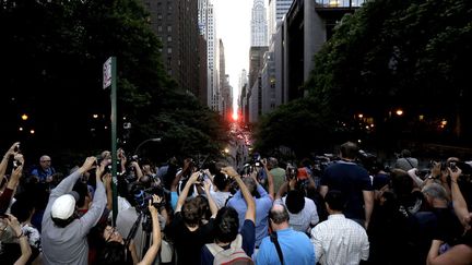 Des photographes amateurs sont r&eacute;unis sur la 42e rue &agrave; New York (Etats-Unis) pour observer "Manhattanhenge", le 11 juillet 2012. (JULIO CORTEZ / AP / SIPA)