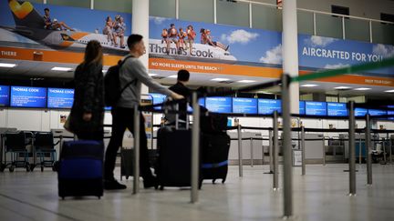 Des passagers passent devant un comptoir fermé du voyagiste Thomas Cook, à l'aéroport de Gatwick à Londres, le 23 septembre 2019. (TOLGA AKMEN / AFP)