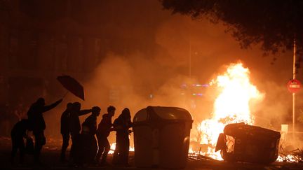 Des manifestants derrières une barricade enflammée, le 18 octobre 2019, à Barcelone. (PAU BARRENA / AFP)