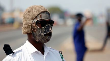 Le 31 mars, dans le quartier de Madina à Accra, au Ghana, un membre du personnel de sécurité du conseil municipal n’a pas hésité à se confectionner un masque maison pour contrôler le trafic. Tous les déplacements interurbains de véhicules sont suspendus suite aux déclarations la veille du président ghanéen. Le chef de l’Etat a ordonné que soient mises en confinement total pour plusieurs semaines la région métropolitaine du Grand Accra et la région métropolitaine de l'agglomération de Kumasi. Toute personne résidant dans ces zones doit rester chez elle, excepté pour faire des provisions, acheter des médicaments ou effectuer des transactions bancaires.&nbsp; &nbsp; (FRANCIS KOKOROKO / REUTERS)