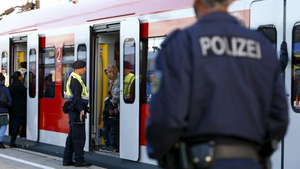 Des migrants montent dans un train en gare de Munich (Allemagne), le 13 septembre 2015. (MICHAELA REHLE / REUTERS)