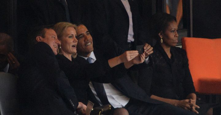 David Cameron, Helle Thorning-Schmidt et Barack Obama (de gauche &agrave; droite) se prennent en photo, &agrave; c&ocirc;t&eacute; de Michelle Obama, lors de l'hommage &agrave; Nelson Mandela, le 10 d&eacute;cembre 2013. (ROBERTO SCHMIDT / AFP)