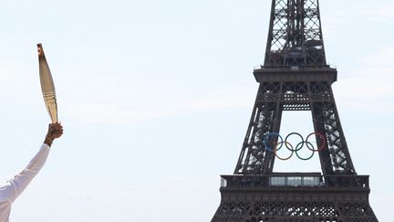 Après avoir sillonné le pays pendant trois mois, la flamme olympique salue la tour Eiffel, à Paris, le 15 juillet 2024. (EMMANUEL DUNAND / AFP)