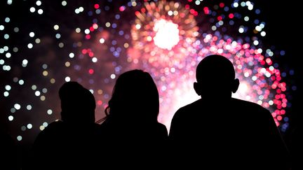 Michelle, Malia et Barack Obama profitent du feu d'artifice de la fête nationale américaine, à la Maison Blanche, le 4 juillet 2014. (PETE SOUZA / THE WHITE HOUSE)