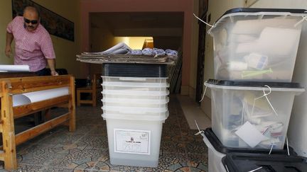 Un employ&eacute; &eacute;gyptien met en place un bureau de vote, le 15 juin 2012 au Caire, &agrave; la veille du d&eacute;but du second tour de l'&eacute;lection pr&eacute;sidentielle.&nbsp; (MOHAMMED ABED / AFP)