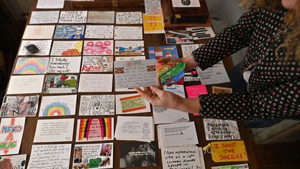 Des cartes postales "secret de confinement", rassemblées par&nbsp;Eleanor Tattersfield, sont exposées dans sa librairie londonienne le 22 mars 2021&nbsp; (BEN STANSALL / AFP)