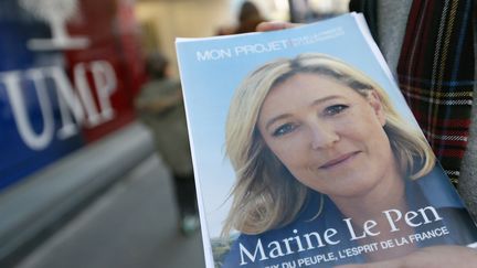 Un militant du FN distribue des tracts devant le si&egrave;ge de l'UMP, &agrave; Paris, le 25 novembre 2012. (KENZO TRIBOUILLARD / AFP)