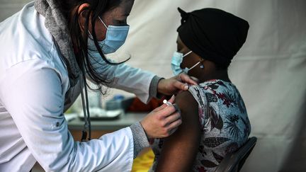 Une femme reçoit une dose du vaccin Pfizer-BioNTech contre le Covid-19 dans une tente installée au pied d'immeubles résidentiels&nbsp;de Noisy-le-Sec, en Seine-Saint-Denis, le 7 mai 2021. (CHRISTOPHE ARCHAMBAULT / AFP)