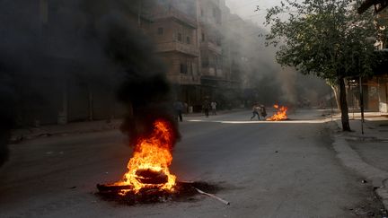 De la fumée s'échappe de pneus incendiés dans une rue d'Alep (Syrie) par des rebelles, dimanche 31 juillet 2016, afin de lutter contre les frappes aériennes pro-gouvernementales. (BEHA EL HALEBI / ANADOLU AGENCY / AFP)