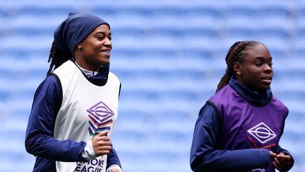 L'attaquante française Marie-Antoinette Katoto et l'attaquante française Sandy Baltimore (à droite) lors d'une séance d'entraînement à la veille du match de la Ligue des Nations féminines entre la France et l'Allemagne, à Lyon, le 22 février 2024. (FRANCK FIFE / AFP)