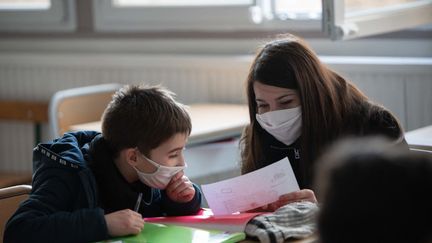 Une enseignante et son élève dans une école de Périgueux (Dordogne), le 11 juillet 2021. (ROMAIN LONGIERAS / HANS LUCAS / AFP)