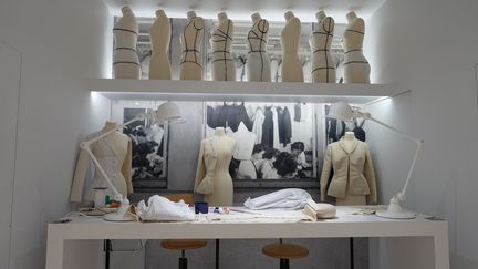 Les savoir-faire et la technique, sans lesquels la haute couture ne saurait exister, sont mis en scène dans un atelier où des ouvrières sont à l’ouvrage, entourées de mannequins, de couturières, de croquis et de toiles. Cet atelier est installé dans une pièce monumentale où est exposé un vestiaire uniquement blanc. 
 (Corinne Jeammet)