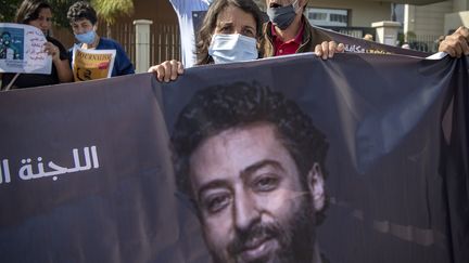 La mère d'Omar Radi tient une banderole lors d'une manifestation de soutien pour son fils journaliste qui comparait devant la justice marocaine à Casablanca, le 22 septembre 2020. (FADEL SENNA / AFP)