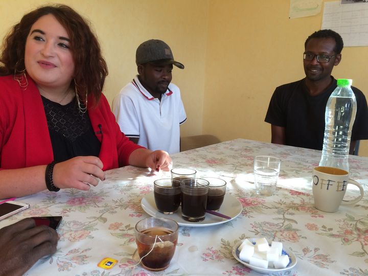 Anaïs Labrousse partage un café avec les demandeurs d'asile occupant les anciens logements de fonction des gendarmes, à&nbsp;Naintré (Vienne).&nbsp; (JULIE RASPLUS / FRANCEINFO)