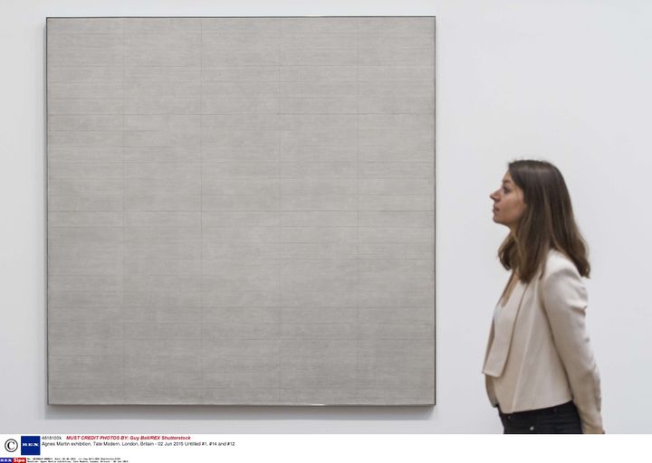 Une visiteuse devant un tableau&nbsp;abstrait de la peintre américano-canadienne Agnès Martin, à la Tate Modern à Londres, le 2 juin 2015. (GUY BELL / SIPA)