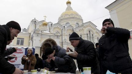 Un repas caritatif préparé et distribué au pied de la cathédrale de Stavropol par une association d'anciens alcooliques et toxicomanes, le 10 janvier 2016. (Eduard Korniyenko / Reuters)