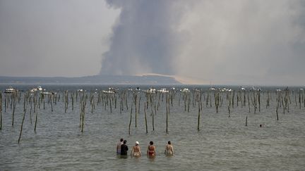 Des touristes regardent la fumée&nbsp;de l'incendie de forêt de la Teste-de-Buche,, le 18 juillet 2022. (OLIVIER MORIN / AFP)