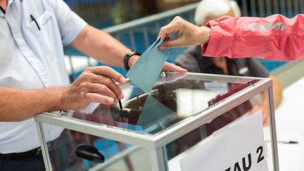 Une femme vote, au premier tour des élections régionales, en Occitanie, le 20 juin 2021. (MATTHIEU RONDEL / HANS LUCAS / AFP)