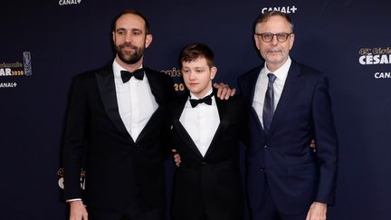 L'équipe du film Au nom de la terre arrive sur le tapis rouge des César : le réalisateur Edouard Bergeon, le producteur Christophe Rossignon et l'acteur Anthony Barjon. Ce dernier est nommé dans la catégorie "meilleur espoir masculin".&nbsp; (THOMAS SAMSON / AFP)