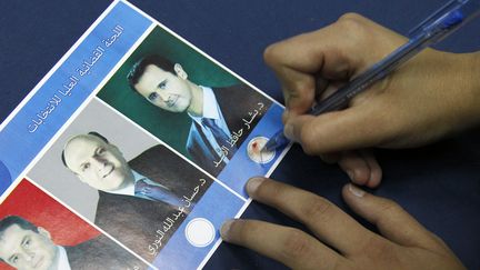 Une femme vote pour Bachar Al-Assad, le 3 juin 2014 &agrave; Damas, lors de la pr&eacute;sidentielle syrienne. (KHALED AL-HARIRI / REUTERS)