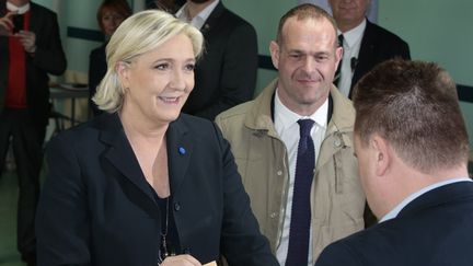 Marine Le Pen, candidate du Front national vote à Hénin-Beaumont (Pas-de-Calais), accompagné du maire FN, Steeve Briois, le 23 avril 2017. (JOEL SAGET / AFP)