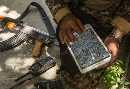 Un soldat kurde de l'YPG consulte les images prises par un drone sur une tablette, à Raqqa, le 1er juillet 2017. (CHRIS HUBY / LE PICTORIUM / MAXPPP)