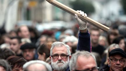 A man holds up a giant pencil during a gathering in Tarbes (Hautes-Pyren&eacute;es) on January 8, 2015, in tribute to the 12 people killed the day before by two gunmen at the editorial office in Paris of French weekly satirical newspaper Charlie Hebdo. (LAURENT DARD / AFP)