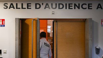 Un policier dans la salle d'audience du tribunal de Besançon (Doubs), le 29 mars 2022. (SEBASTIEN BOZON / AFP)