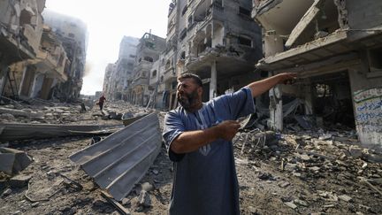 Un Palestinien montre un immeuble détruit par une frappe israélienne dans le camp de réfugiés de Jabalia, dans la bande de Gaza, le 11 octobre 2023. (MAHMUD HAMS / AFP)