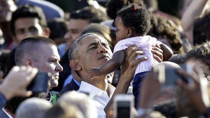 Le président Barack Obama prend un enfant dans ses bras lors de la campagne d'Hillary Clinton à Chapel Hill (Caroline du Nord), le 2 novembre 2016. (GERRY BROOME / AP / SIPA)