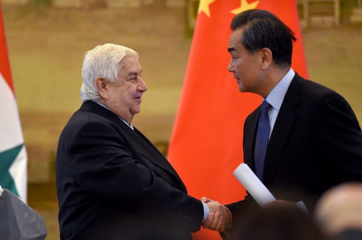 Le ministre syrien des Affaires étrangères, Walid Muallem, sert la main de son homologue chinois, Wang Yi, lors d'une conférence de presse le 24 décembre 2015 à Pékin. (WANG ZHAO / AFP)