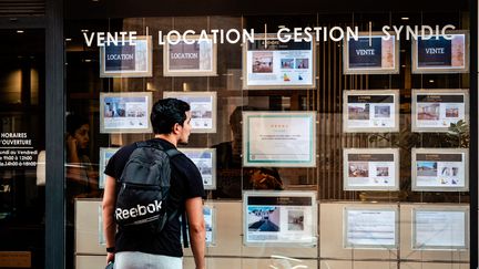 A passerby looks at real estate advertisements in Toulouse, September 27, 2023. (ADRIEN NOWAK / HANS LUCAS / AFP)