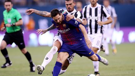 Le Barcelonais Lionel Messi à la lutte avec le défenseur turinois Stefano Sturaro. (ELSA / GETTY IMAGES NORTH AMERICA)