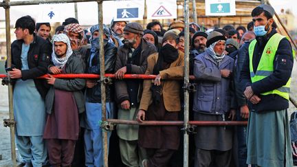 Des Afghans attendent pour recevoir de la nourriture de la part d'une ONG à Kaboul (Afghanistan), le 25 décembre 2022. (- / AFP)