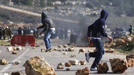 Des Palestiniens jettent des pierres sur des militaires isra&eacute;liens lors d'affrontements &agrave; Ramallah (Cisjordanie), le 13 f&eacute;vrier 2012. (MOHAMAD TOROKMAN / REUTERS)