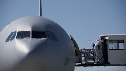 Du personnel médical embarque un patient à bord d'un avion médicalisé, en mars 2020. Photo d'illustration. (SEBASTIEN BOZON / AFP)